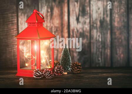 Merry Christmas.Noel concept background.Red Christmas Lantern avec arbre de noël et cônes de pin sur table en bois Banque D'Images