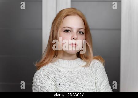 portrait d'une triste belle fille caucasienne de 16 ans dans un pull blanc tricoté Banque D'Images