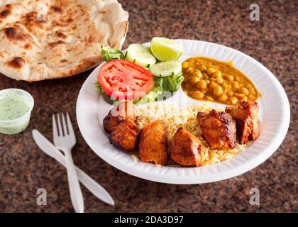 Plat de kebab de poulet à l'arrière avec riz, pois chiches, salade et pain naan Banque D'Images