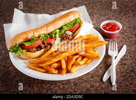 Sandwich au fromage et au steak de Philly de style américain avec frites et ketchup sur une surface en granit Banque D'Images