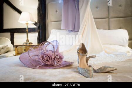 Chaussures de fête et chapeau habillé sur un lit dans une chambre d'hôtel. Banque D'Images