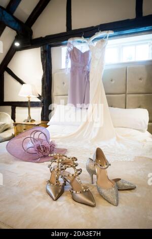 Chaussures de fête et chapeau habillé sur un lit dans une chambre d'hôtel. Banque D'Images