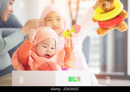 Bébé musulman joue avec des jouets colorés dans le salon. Banque D'Images