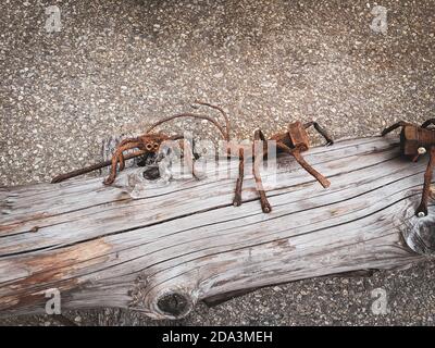 Trient/Suisse - août 6 2019 : un fourmis et une araignée construits à partir de vis et de clous. Travail aléatoire de décoration artistique sur une bûche. Animaux rouillés. Asphalte Banque D'Images