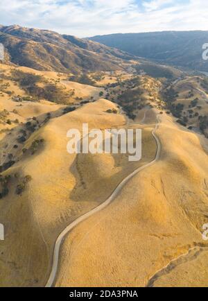 La lumière du soleil dorée brille sur les collines ondoyantes du nord de la Californie. Ces belles collines érodées deviennent vertes une fois l'hiver apporte la pluie saisonnière. Banque D'Images