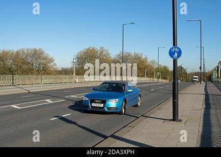 une audi traverse le pont de twickenham, dans le sud-ouest de londres, en angleterre, en passant par un panneau d'itinéraire partagé pour les jambes, par une journée ensoleillée en automne Banque D'Images