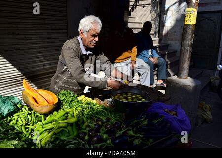 Udaipur, Rajasthan, Inde - décembre 2016: Vieux vendeur vendant des légumes sur le marché de rue. Vendeur indien près du vendeur de rue le matin Banque D'Images