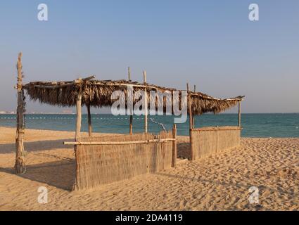 Un hangar à palmiers sur une plage à Doha Qatar. Banque D'Images