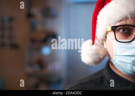 Concept de Noël, homme caucasien portant un masque médical et chapeau de santa Banque D'Images