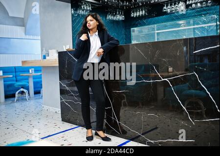 Magnifique femme indienne porte habillé posant au café près du comptoir de bar. Banque D'Images