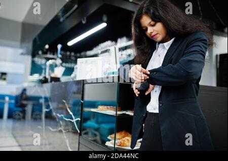 Magnifique femme indienne porte habillé posant au café près du comptoir de bar. Banque D'Images