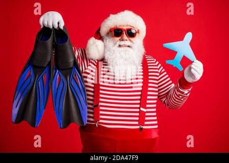 Photo de grand-père barbe grise tenir papier avion équipement de plongée papas porter santa claus x-mas costume bretelles pare-soleil rayés chemise capuchon isolé Banque D'Images