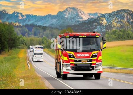 Nouveau camion de feu Scania P dans la circulation routière à travers le paysage magnifique. Image composite. Banque D'Images