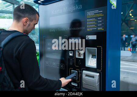 Un touriste achète un billet de bus pour la première fois à l'aide d'une machine à billets électroniques. Banque D'Images