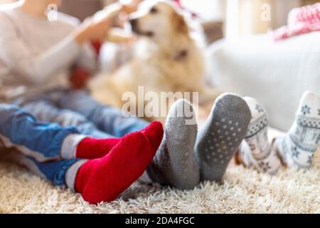 Famille dans des chaussettes chaudes assis dans une atmosphère de Noël confortable À la maison Banque D'Images