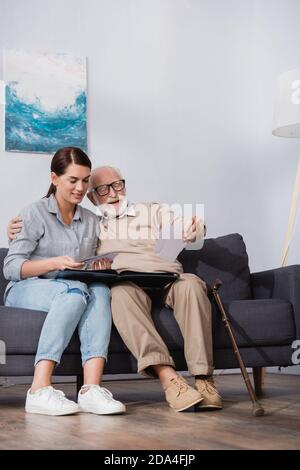 homme âgé et fille adulte regardant ensemble des photos de famille Banque D'Images