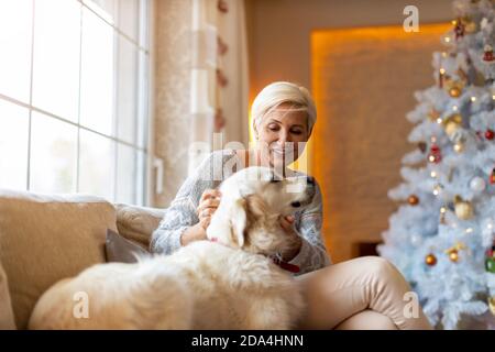 Femme et son chien qui apprécient Noël ensemble à la maison Banque D'Images
