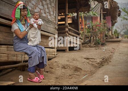 Mae Hong son, Thaïlande, mars 2012. Une femme ethnique Karen avec sa fille à la porte de son foyer. Ces personnes sont connues comme les femmes à long cou becau Banque D'Images