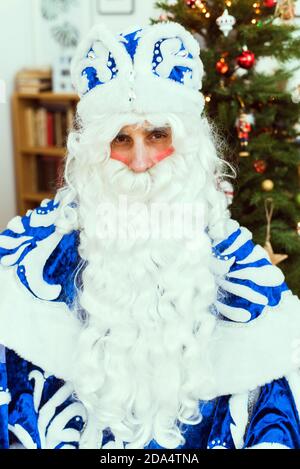 Le Père Noël en fourrure bleue est assis dans une pièce chaude et regarde la caméra. Concept nouvel an et Noël. Banque D'Images