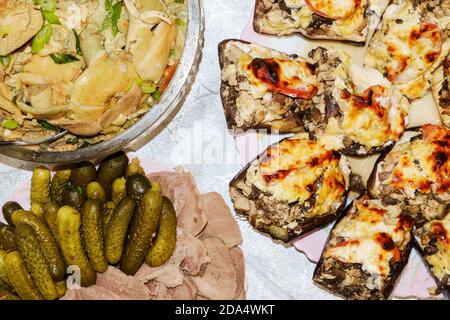 Table de fête. La langue de porc bouillie aux cornichons et aux épices, les champignons salés assaisonnés d'herbes, l'aubergine farcie. Mise au point sélective. Banque D'Images