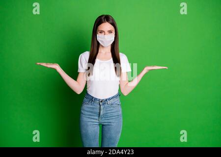 Photo de femme douce porter un masque blanc montrant des écailles arrière-plan vert isolé d'espace vide Banque D'Images