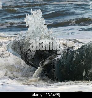 L'iceberg est éclaboussé à Diamond Beach, Hornafjorour, région orientale, Islande Banque D'Images