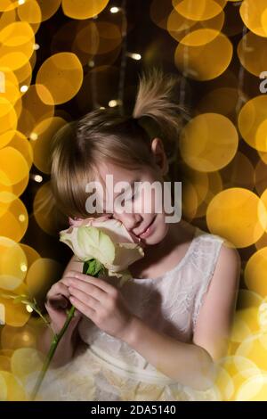 Jeune adorable jolie fille avec rose de son père plus arrière-plan sombre Banque D'Images