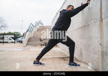 Homme athlétique qui étire les jambes avant de faire de l'exercice. Banque D'Images