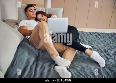 Jeunes conjoints regardant une émission de télévision sur l'ordinateur portable Banque D'Images