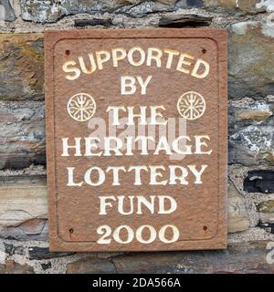 Signe isolé soutenu par le Heritage Lottery Fund 2000, à Lybster, Caithness, Écosse. Panneau marron et blanc sur le mur rustique en pierre. Banque D'Images