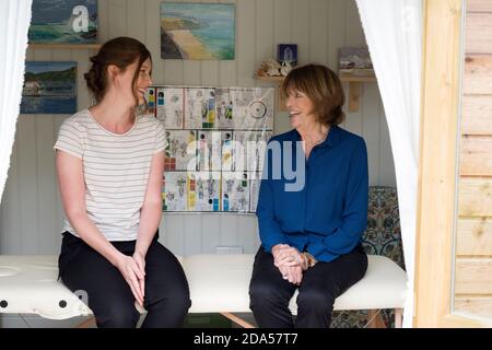 Femme et femme thérapeute parlant assis sur un canapé de traitement. Banque D'Images