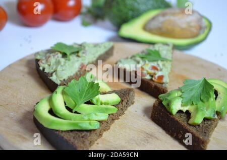 Un délicieux bol de guacamole à côté d'ingrédients frais sur une table avec des chips de tortilla et de la salsa. Sandwich avec guacamole, piment rouge, lime, citron Banque D'Images