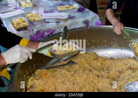 Chef mettant du riz cuit dans des assiettes. Cuisine traditionnelle turque: Pilav. Le concept de l'humanitarisme. Barda - Azerbaïdjan : 10 octobre 2020 Banque D'Images