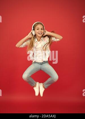 hipster kid continue de bouger. danse énergique des enfants. bonne enfance. inspirée de la musique. vacances printanières. fille célébrant la victoire. petite fille dans les écouteurs. plaisir en mouvement. petite star rock. Banque D'Images