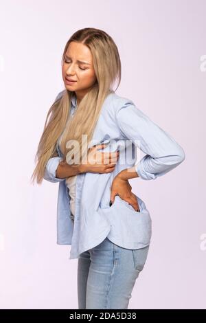 Jeune femme caucasienne ayant des douleurs musculaires ou nerveuses chroniques dans son dos après avoir travaillé. Maladies de la colonne vertébrale, scoliose, ostéoporose Banque D'Images