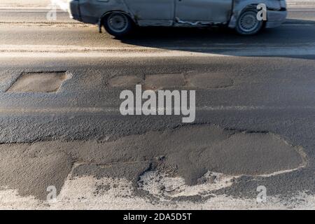 Trou, rut sur la route asphaltée dans la ville. Route nécessitant une réparation, exemple de corruption dans la réparation des routes en Russie Banque D'Images