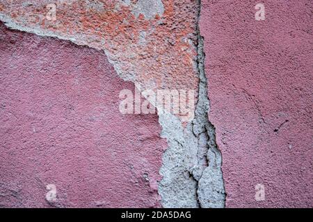 mur de grunge rose avec de la peinture fissurée et des fissures Banque D'Images