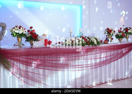 Table festive avec verres, bougies et bouquet de fleurs. Cuisine fine réception de mariage restauration Banque D'Images