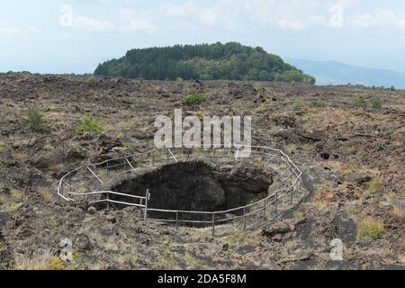 Une des trois Grottes d'Ange, semblable à un chaudron, au milieu de la lave aride de 1651 sur le sentier de marche du Mont Egito au Mont Scavo dans le Parc Etna, Sicile Banque D'Images