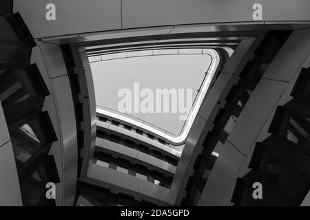 Couleur et ton noir et blanc, faible angle vue en perspective diminuée atrium intérieur entouré d'une façade en courbure et d'un mur avec grand trou. Banque D'Images