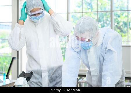 Couple scientifique mâle portant une combinaison de protection sérieuse pour les recherches sans succès en laboratoire. Portrait du scientifique Banque D'Images