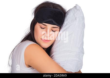 femme portant un masque de sommeil et tenant un oreiller. Banque D'Images