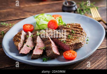 Steak grillé juteux bœuf moyen rare avec épices et salade fraîche. Banque D'Images