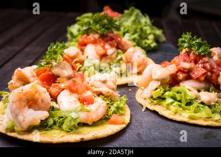Tacos aux crevettes sur tortilla à coque dure avec garniture mexicaine arrière-plan en bois sombre Banque D'Images