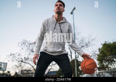 Jeune homme jouant au basket-ball dans la rue Banque D'Images