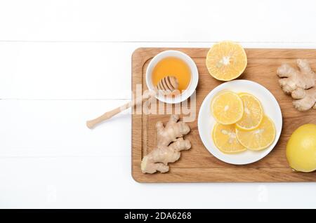 Gingembre avec citron et tisane sur bureau en bois sur blanc arrière-plan Banque D'Images