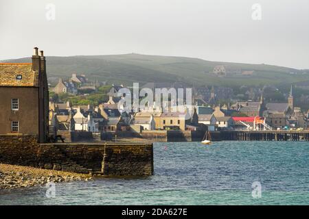 Vue sur le front de mer des maisons et la colline dans la ville portuaire d'Orkney De Stromness Banque D'Images