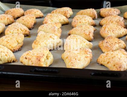 Biscuits sur une plaque de cuisson. Biscuits de sucre de fromage cottage triangulaire. Banque D'Images