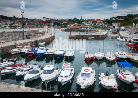 Vue sur le port de la ville Cantabrique de Comillas avec des bateaux de plaisance en première ligne et la ville en arrière-plan. Banque D'Images