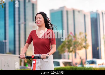 Femme ayant un tour sur le scooter électrique pour rapide et transport facile dans une ville moderne Banque D'Images